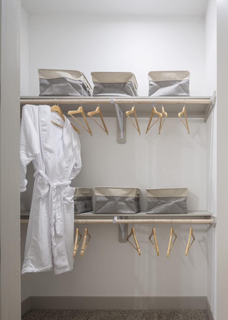 Spacious closet with hangars, storage boxes, and white robe hanging at Broadstone Emeline Heights in Houston, TX