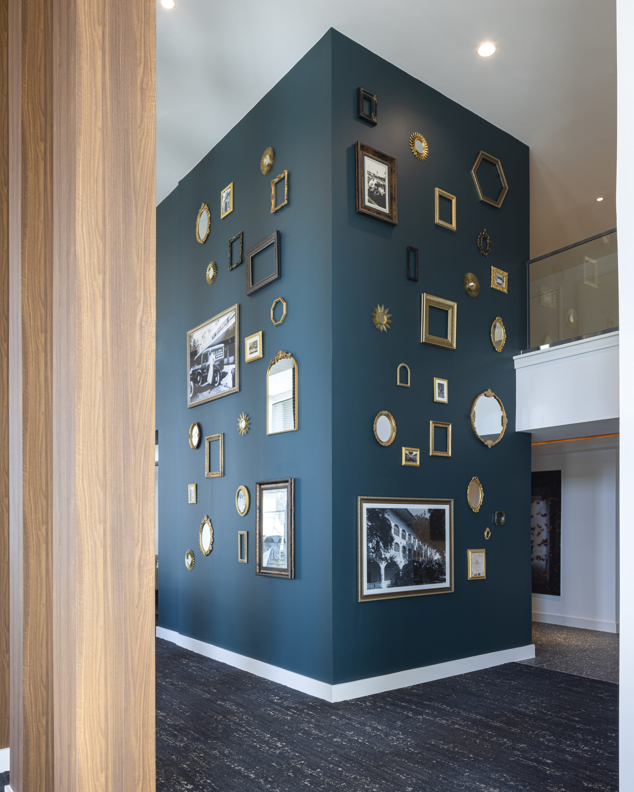 blue teal wall with pictures on it of varying sized at Broadstone Emeline Heights in Houston, TX