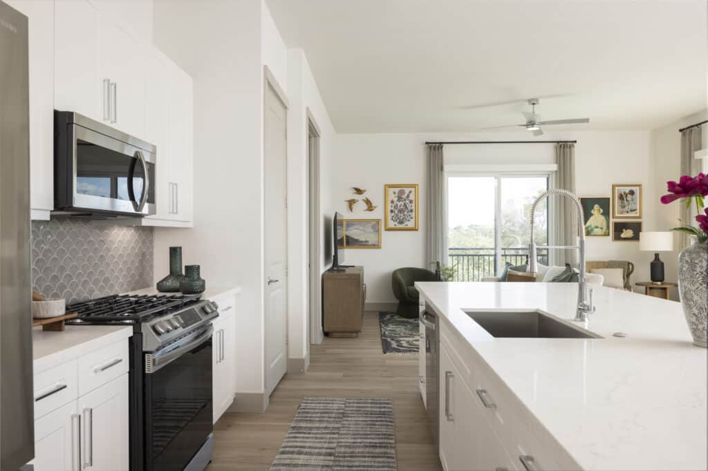 Kitchen with white counters and cabinets with stainless appliances at Broadstone Emeline Heights in Houston, Texas